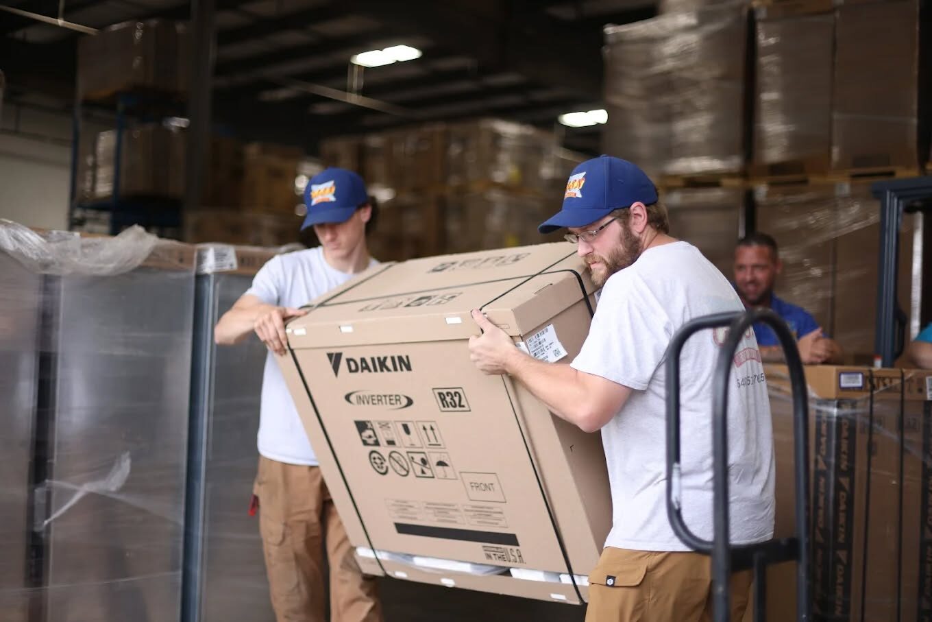 two employees carrying a daikin box
